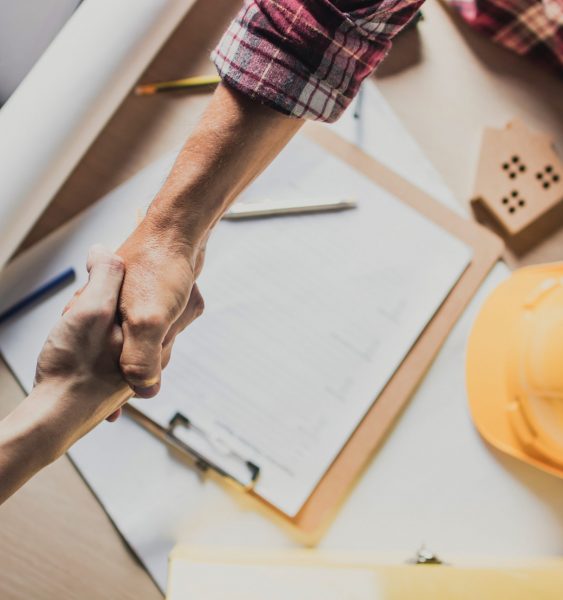 top view hand shake of engineer and  building contractor on table